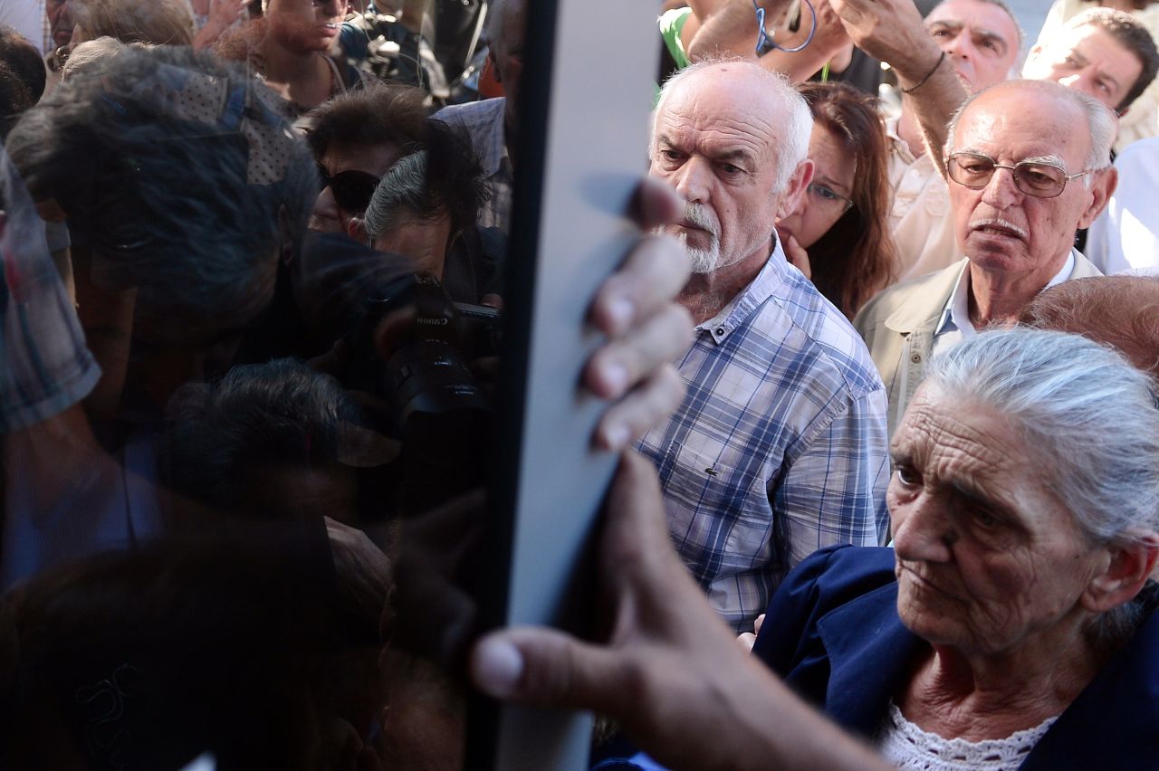 Pensioners queue outside a national Bank branch in Athens on Tuesday, July 1, as banks only opened for the retired to allow them to cash up to 120 euros.