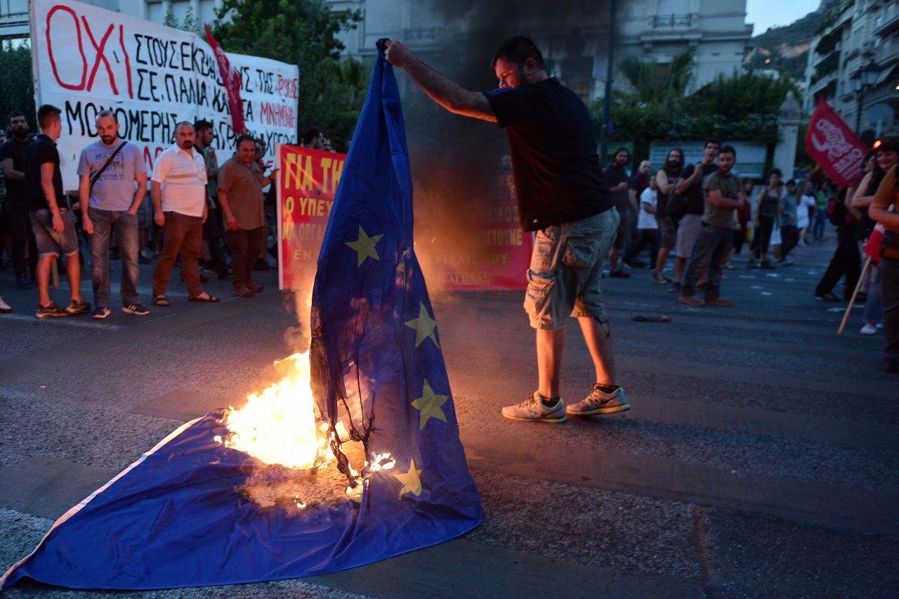 An anti-EU protester burns an EU flag in front of the European Commission offices.