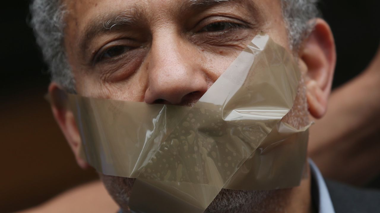 A protester demanding freedom for Al Jazeera reporter Ahmed Mansour stands with his mouth taped shut to symbolize the persecution of journalists in Egypt outside the court and prison where Mansour is being held on June 22, 2015 in Berlin, Germany.