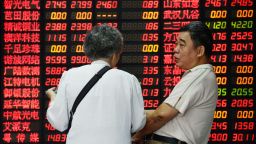 Investors talk in front of a board displaying share prices at a security firm in Shanghai on July 1, 2015. Shanghai shares closed down more than five percent on July 1, resuming their downward trajectory a day after recording their biggest gains in more than six years. AFP PHOTO CHINA OUT (Photo credit should read STR/AFP/Getty Images)