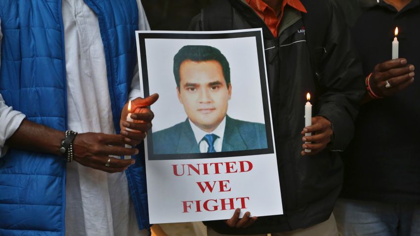 Indian journalists hold candles and a photograph of Akshay Singh during a memorial meeting in Bangalore, India, Monday, July 6, 2015. Singh, an Indian television journalist died under mysterious circumstances Saturday while on assignment covering allegations of a massive scheme to manipulate the results of entrance examinations for government jobs and medical colleges in the central Indian state of Madhya Pradesh. The alleged scam labeled "Vyapam" by Indian media after the Hindi name of the state's professional examination board since the story first surfaced in 2013. (AP Photo/Aijaz Rahi)