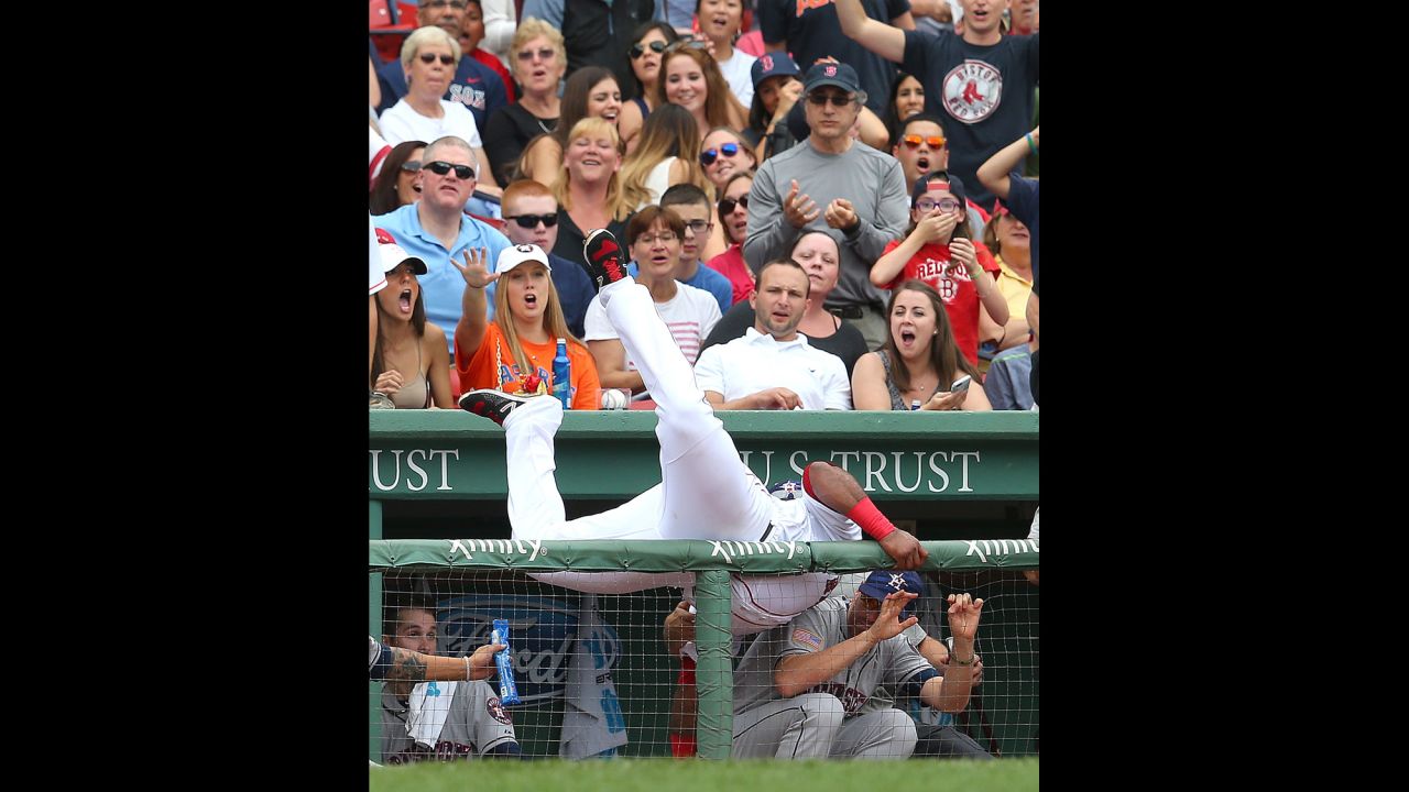 Boston's Pablo Sandoval falls into Houston's dugout while catching a ball Saturday, July 4, in Boston's Fenway Park.