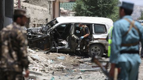 Security personnel inspect a damaged vehicle after a suicide attack that targeted a NATO convoy in Kabul.