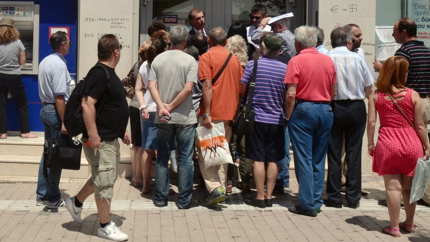 Caption:A woman withdraws money from an ATM machine while others speak to an official of the bank, in Athens, on July 6, 2015. More than 61 percent of Greek voters rejected fresh austerity demands by the country's EU-IMF creditors in a historic referendum, official results from over 95 percent of polling stations showed. Germany said Monday that there was currently 'no basis' for talks with Greece on a new bailout package or debt relief, following a resounding 'No' in a referendum on creditors' proposals. AFP PHOTO/ LOUISA GOULIAMAKI (Photo credit should read LOUISA GOULIAMAKI/AFP/Getty Images)
