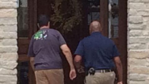 Ex-Subway pitchman Jared Fogle, left, walks back into his Zionsville, Indiana, home as investigators search it.
