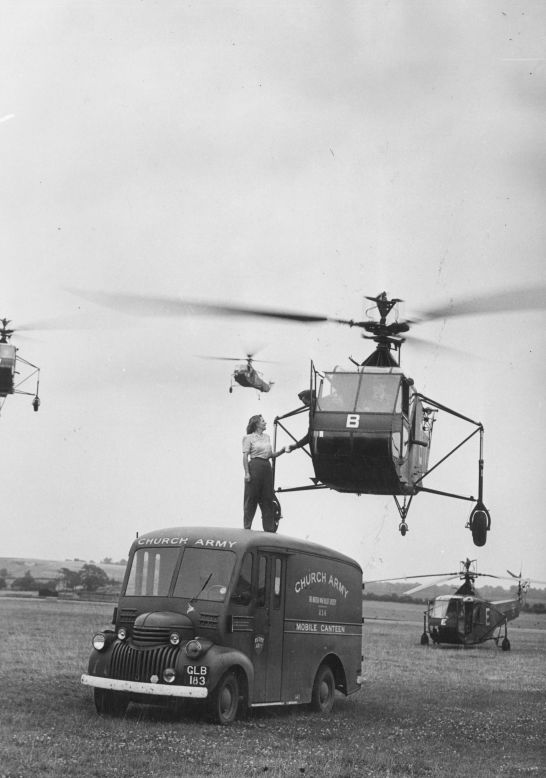 A Church Army canteen worker is seen here handing a cup of tea to the pilot of a Sikorsky R-4 helicopter hovering overhead at an RAF Helicopter School in Andover, England, in 1945. Though not an airplane, the R-4 was the world's first mass-produced helicopter and the first helicopter used by the United States Army Air Forces and the British Royal Air Force and Royal Navy.