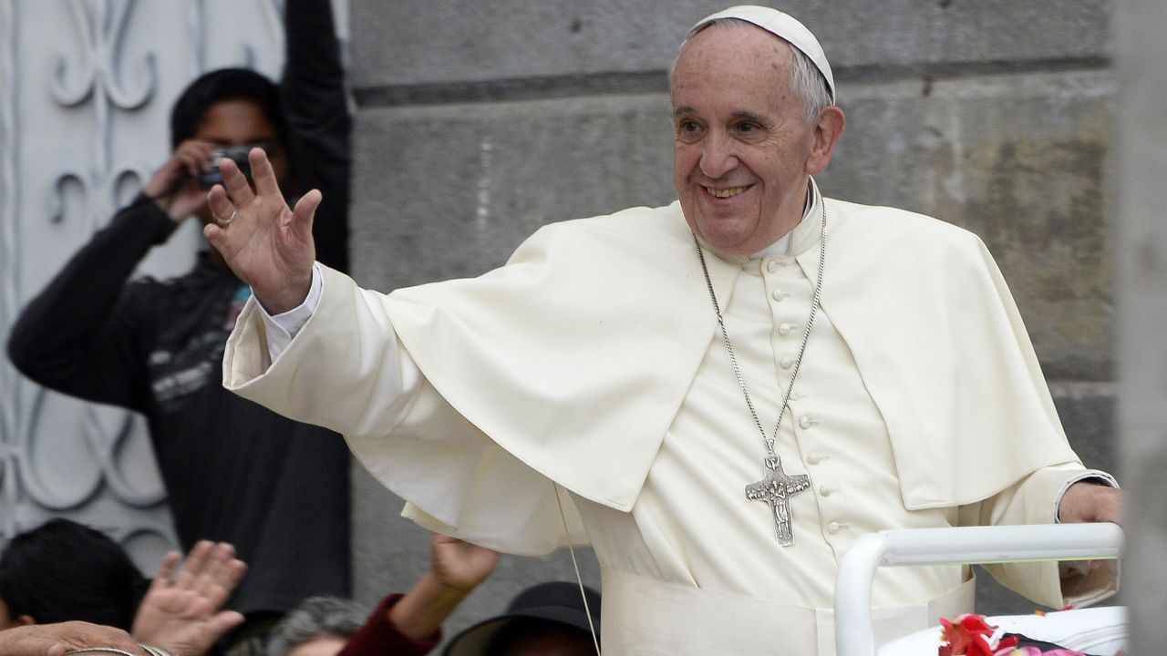 Pope Francis waves as he rides in the Popemobile through the Ecuadorean capital, Quito, on July 7, 2015.