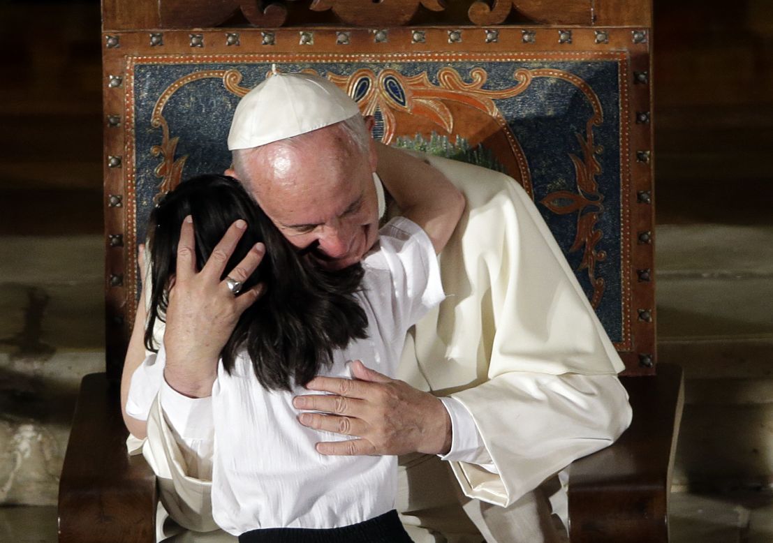 The Pope hugs a child during his visit to the San Francisco Church in Quito on July 7.