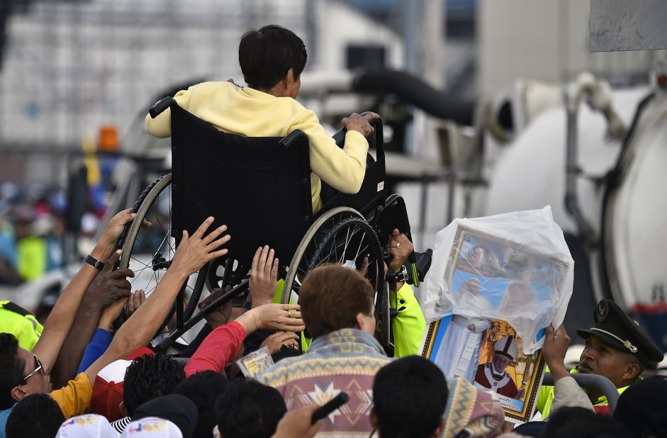A disabled woman in Quito is lifted in a wheelchair during a Mass officiated by Pope Francis on July 7.