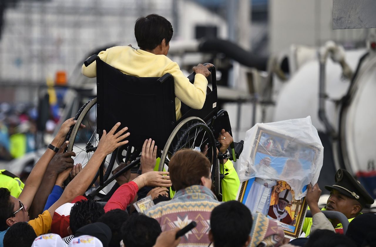 A disabled woman in Quito is lifted in a wheelchair during a Mass officiated by Pope Francis on July 7.