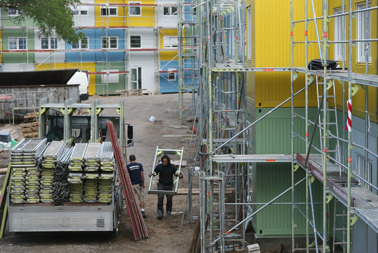Workers construct a container facility in Berlin's Zehlendorf district that will house refugees and asylum applicants on July 9. The wars in Syria and Iraq, as well as crises and economic desperation in Africa and the Balkans, have contributed to the rising tide of refugees entering Germany.