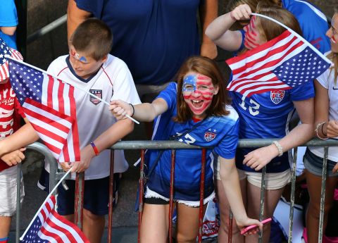 A young fan cheers while waiting for the ticker tape parade, the first in New York for a women's sports team.