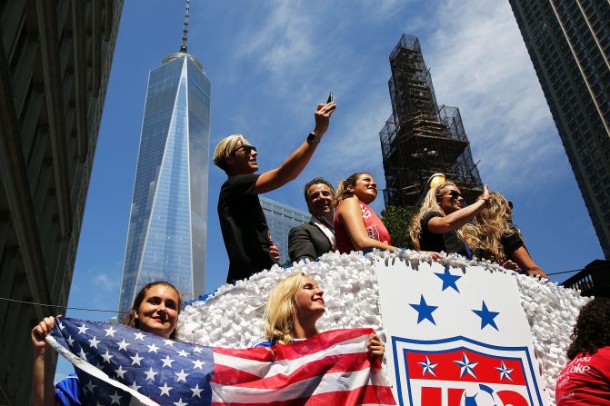 U.S. forward Abby Wambach takes a photo aboard a float. The floats carried the players from Battery Park to City Hall.