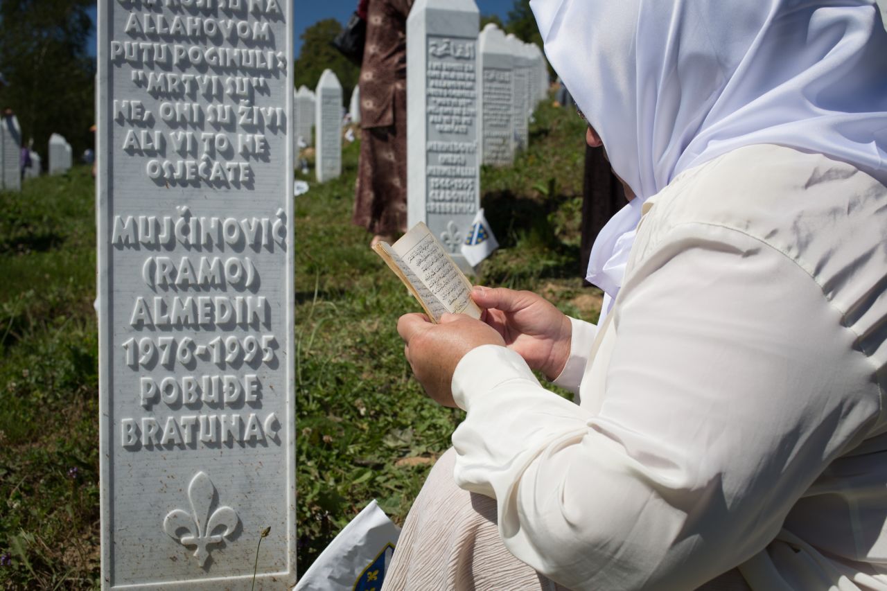 A Bosnian women prays at the grave of a relative in Srebrenica cemetery.