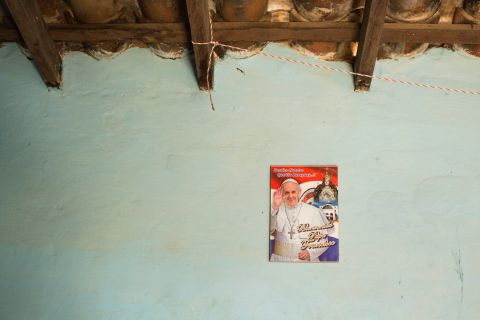 Asuncion Jimenez has a sole poster of Pope Francis hanging beneath a ceramic tile roof. 