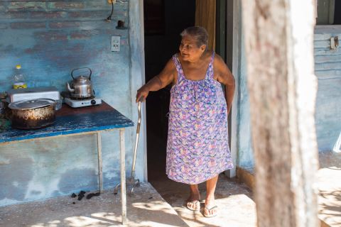 Asuncion Jimenez prepares lunch for family members outside her home. She is looking forward to meeting the Pope when he visits her family.  She hopes to sit next to him and make him lunch. 