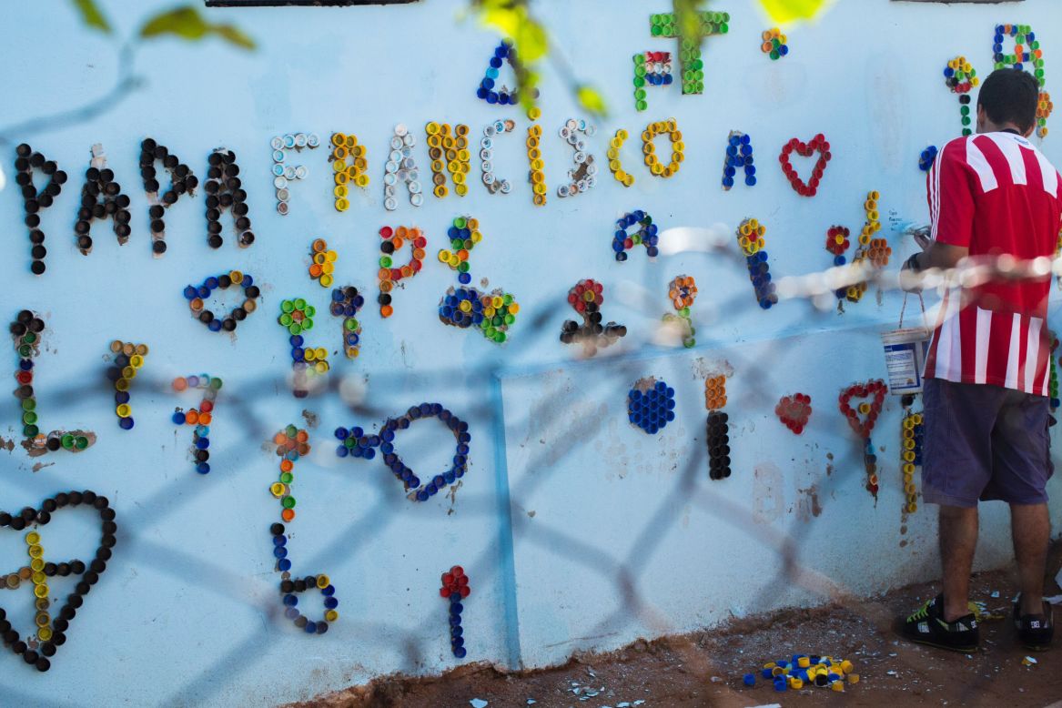 Neighbors paint the walls and write Pope Francis' name to celebrate his visit to Bañado Norte.
