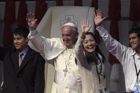 Pope Francis waves during a meeting with young people at the "Costanera" in Asuncion, Paraguay, on Sunday, July 12, the final day of his eight-day tour of South America.