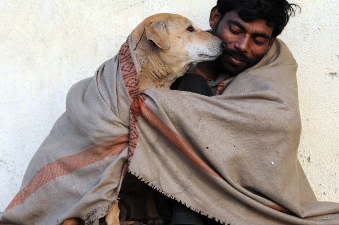 An Indian man shares his shawl with a stray dog in Ahmedabad, Gujarat, on a cold morning on January 19, 2012.
