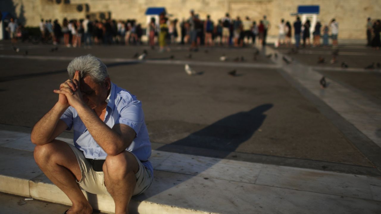 A man sits alone with his thoughts as protesters gather outside the Greek parliament to demonstrate against austerity after an agreement for a third bailout with eurozone leaders on July 13, 2015 in Athens, Greece. The bailout is conditional on Greece passing agreed reforms in parliament by Wednesday which includes streamlining pensions and rasing more raise tax revenue.