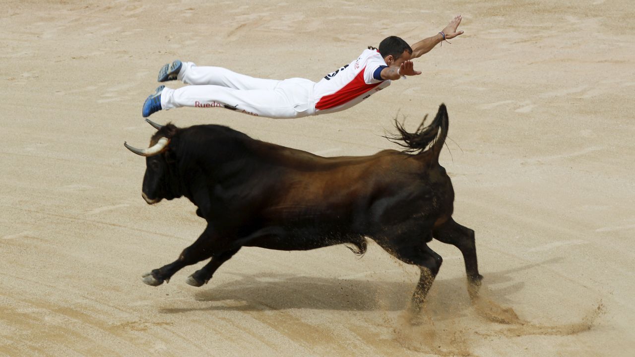 A "recortador" jumps over a bull during the San Fermin festival in Pamplona, Spain, on Saturday, July 11.