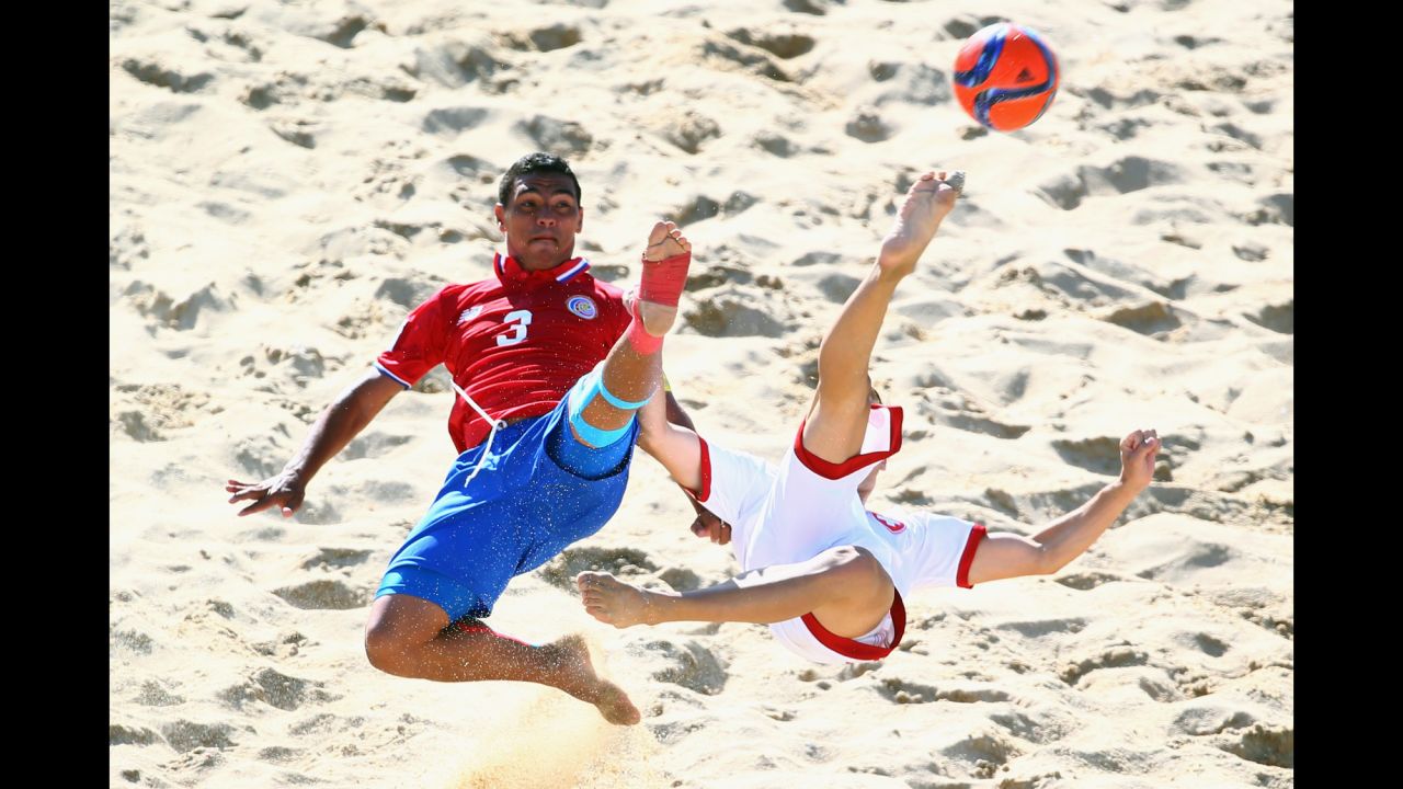 Costa Rica's Jose Mendoza, left, and Switzerland's Noel Ott reach for a ball during a match at the Beach Soccer World Cup on Saturday, July 11. Switzerland won the match 4-3 in Espinho, Portugal.