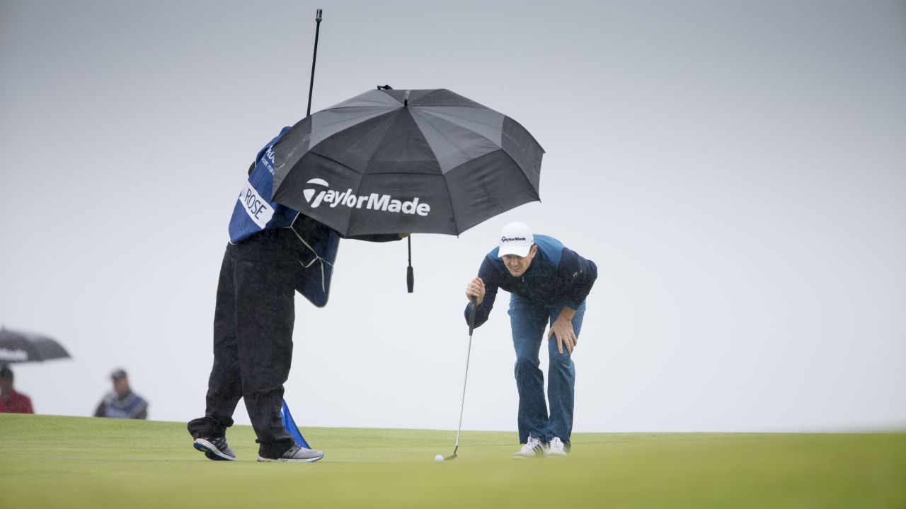 Justin Rose tries to keep dry as he lines up a putt at the Scottish Open on Friday, July 10.