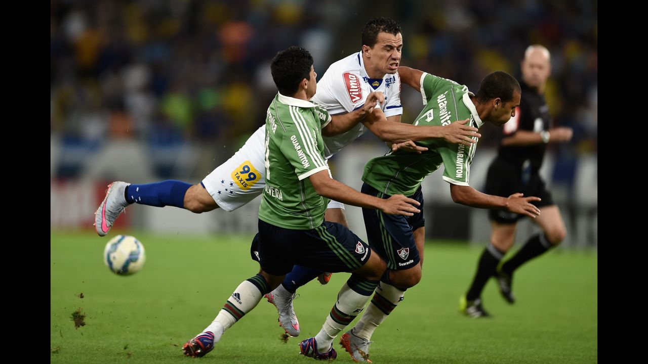 Cruzeiro's Leandro Damiao, center, crashes into two Fluminense players during a Brazilian league soccer match in Rio de Janeiro on Thursday, July 9.
