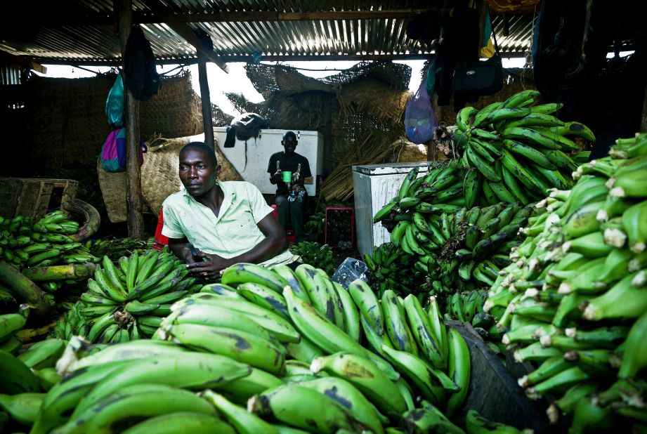 A South Sudanese market trader sits in his shop where he sells imported bananas from Uganda. Another disease, called "BXW," has nearly destroyed Uganda's banana industry about a decade ago.