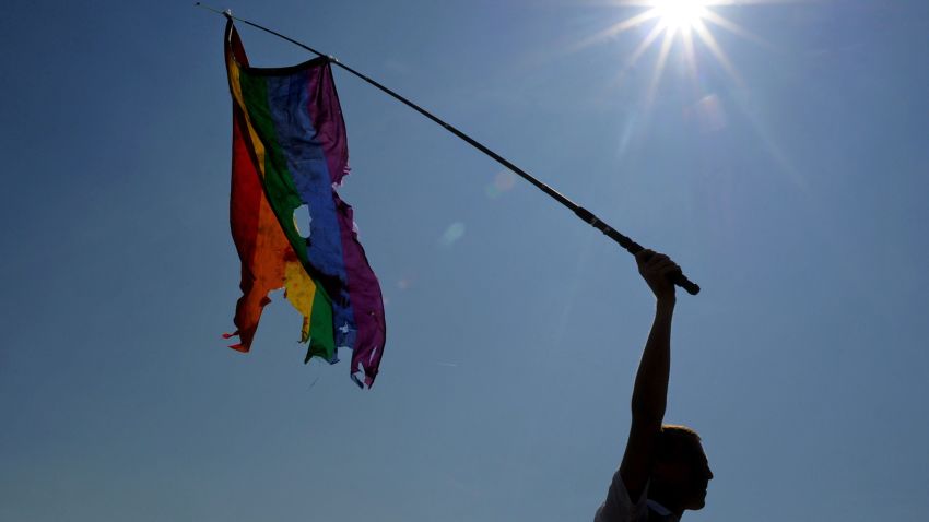 A gay rights activist waves a damaged rainbow flag during a gay pride march in St. Petersburg on July 26, 2014. AFP PHOTO / OLGA MALTSEVA (Photo credit should read OLGA MALTSEVA/AFP/Getty Images)