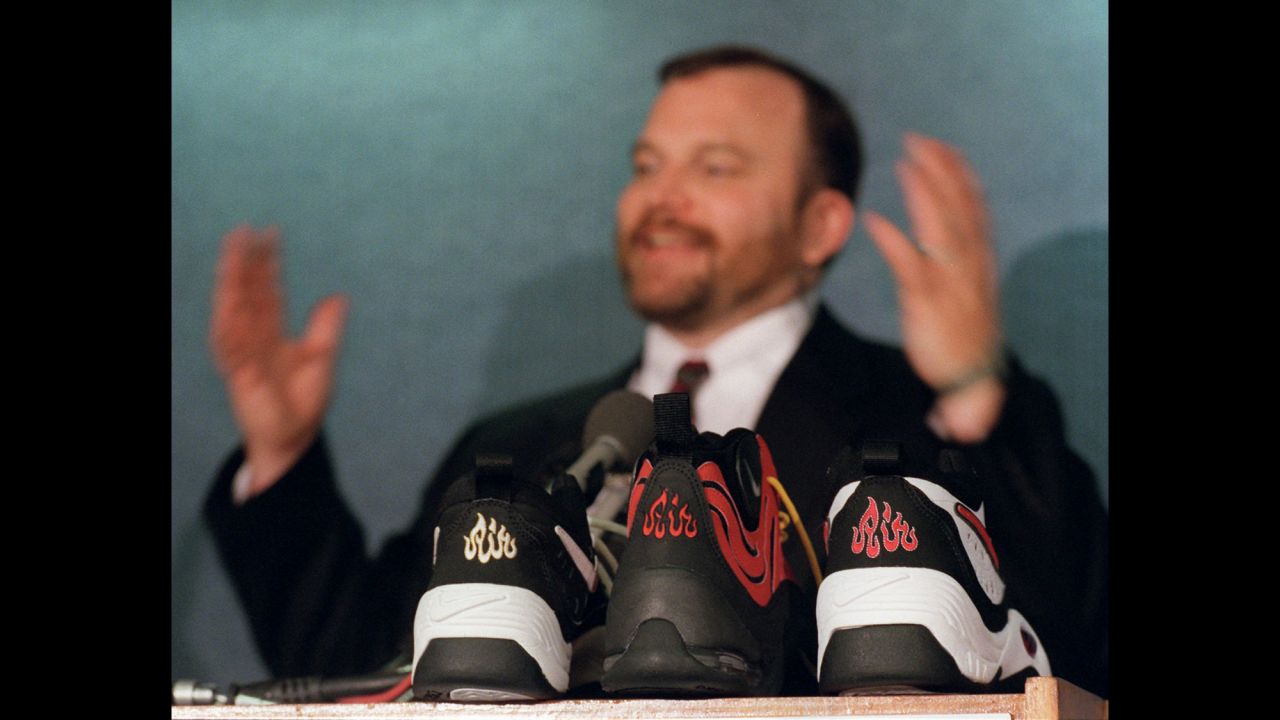 Ibrahim Hooper, communications director of the Council on American-Islamic Relations, gestures during a June 1997 news conference with samples of Nike shoes in the foreground. Hooper's group said the "Air" symbol resembled "Allah" in Arabic, and the shoes were recalled. Nike apologized to Muslims for any unintentional offense.