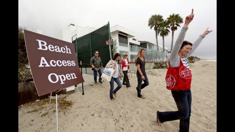 Beachgoers celebrate as they walk onto Billionaire's Beach after a ribbon-cutting ceremony in early July for the new path, which lies halfway between the original path by the pier and one near David Geffen's compound at the other end of the beach. The so-called Geffen gate opened in 2007 after the entertainment mogul lost a court fight to block access.