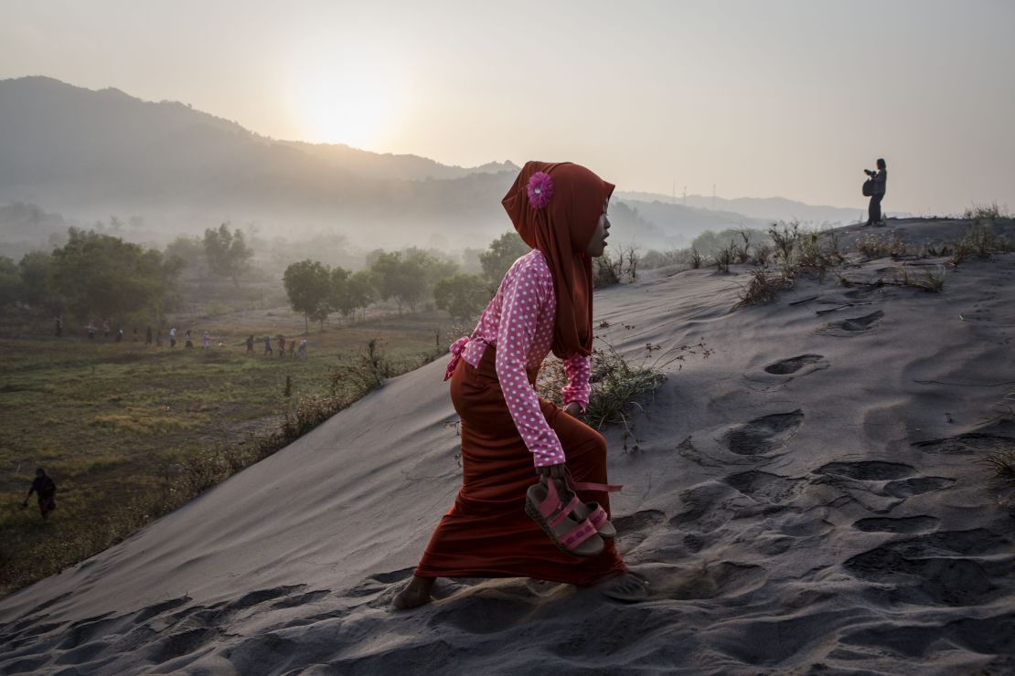 A Muslim woman walks on "sea of sands" as she prepares for prayer at Parangkusumo Beach in Yogyakarta, Indonesia. 