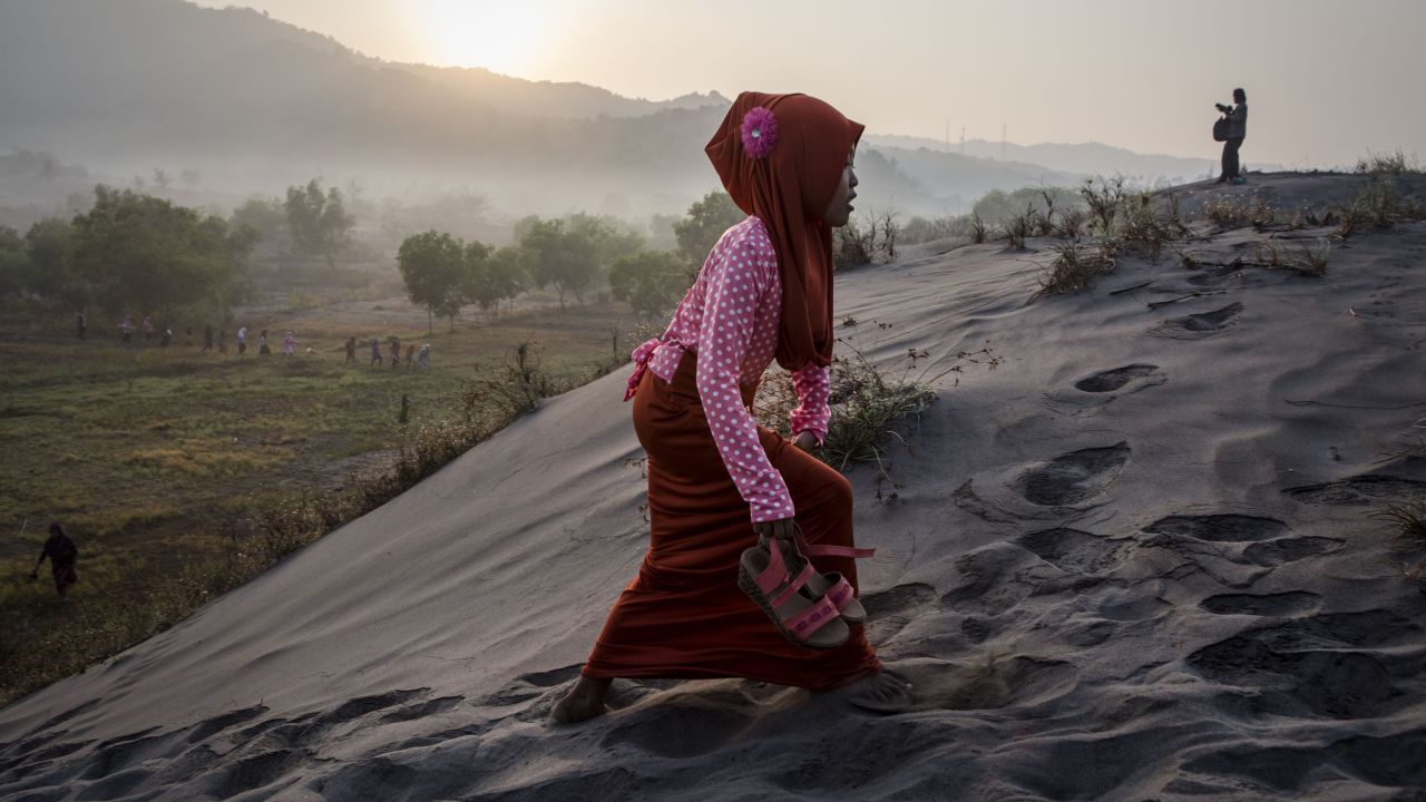 A Muslim woman walks on "sea of sands" as she prepares for prayer at Parangkusumo Beach in Yogyakarta, Indonesia. 