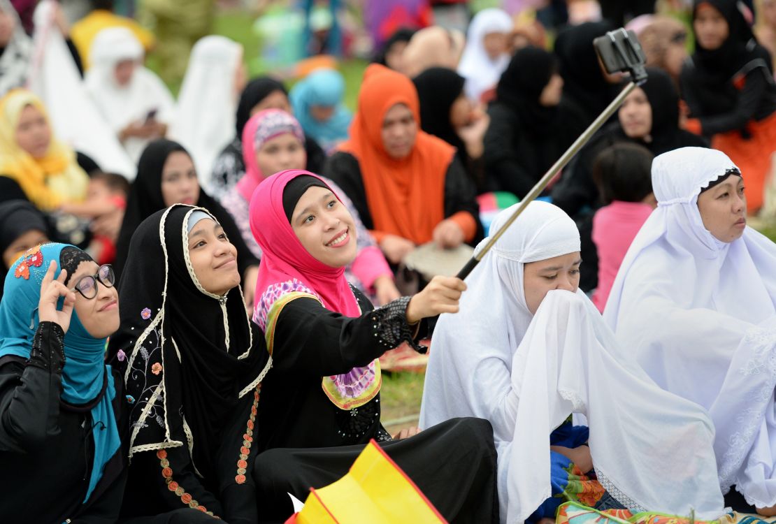 Young Muslims devotees take a selfie before Friday prayers to mark the end of Ramadan in Manila, Philippines.