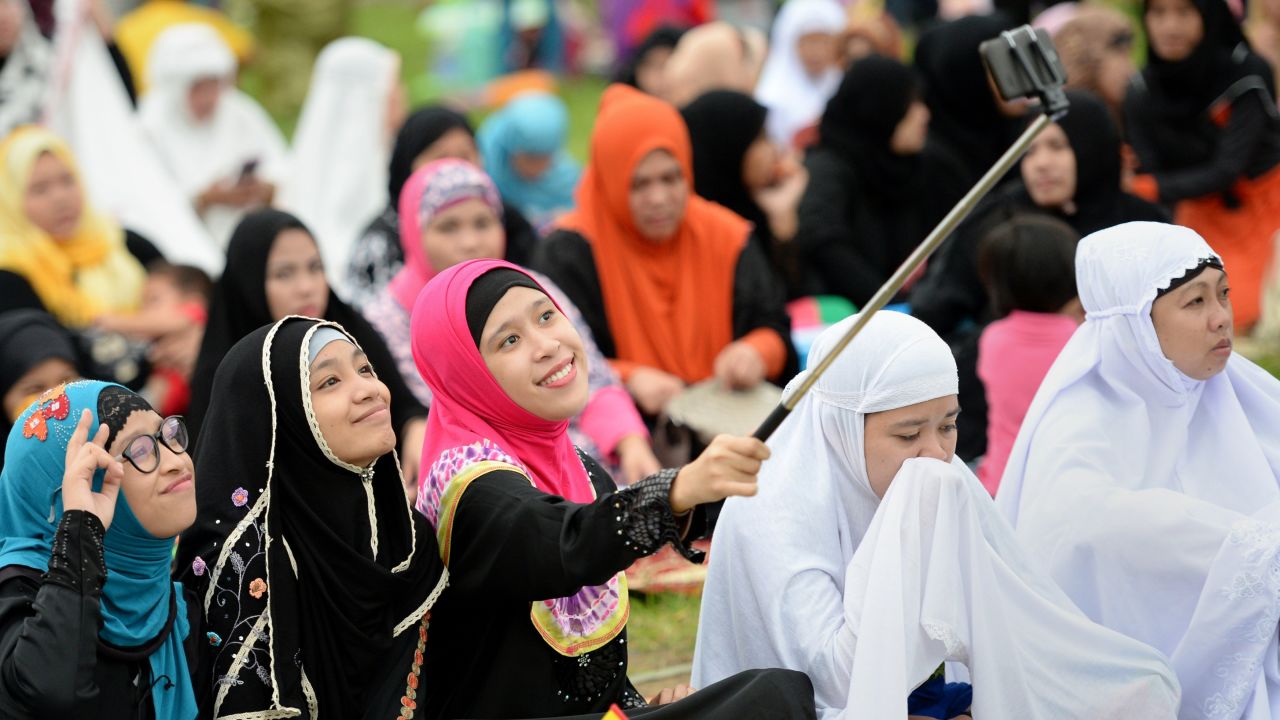 Young Muslims devotees take a "selfie" prior to Friday prayers to mark the end of Ramadan last year in Manila, Philippines.