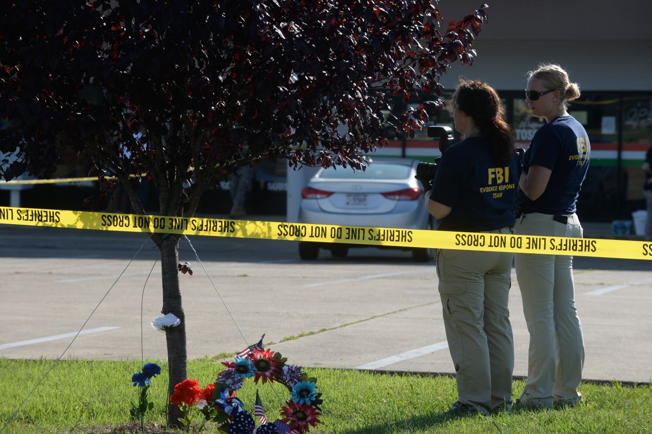 Members of the FBI gather evidence at the scene of the recruiting center shooting on July 16.