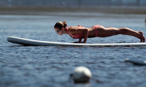 Yoga's explosion in popularity has created a subset of yogi types that populate classrooms in urban centers, which can be intimidating to newbies. This yogi practices a plank pose during a paddleboard yoga session in Miami. 