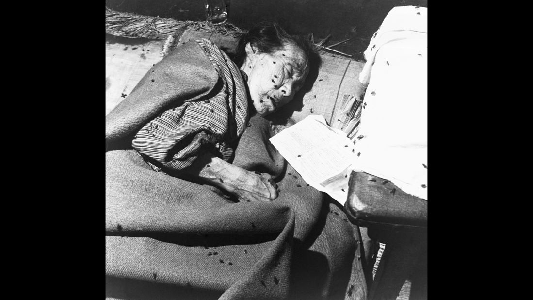 An elderly victim is covered with flies in a makeshift hospital in Hiroshima.