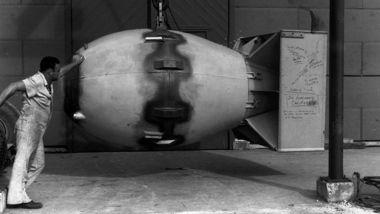 A worker stands next to an atomic bomb, nicknamed "Fat Man," hours before it was dropped on Nagasaki, Japan, on August 9, 1945.