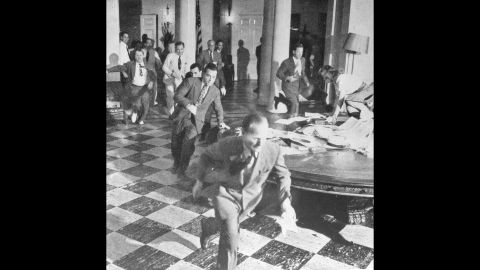 Members of the White House Press Corps rush to telephones after Truman announced Japan's surrender on August 15, 1945.