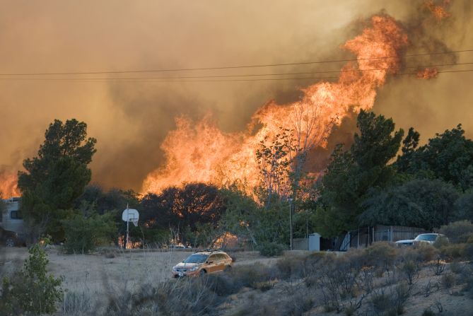 Flames rise over a cluster of homes in Oak Hills on July 17.