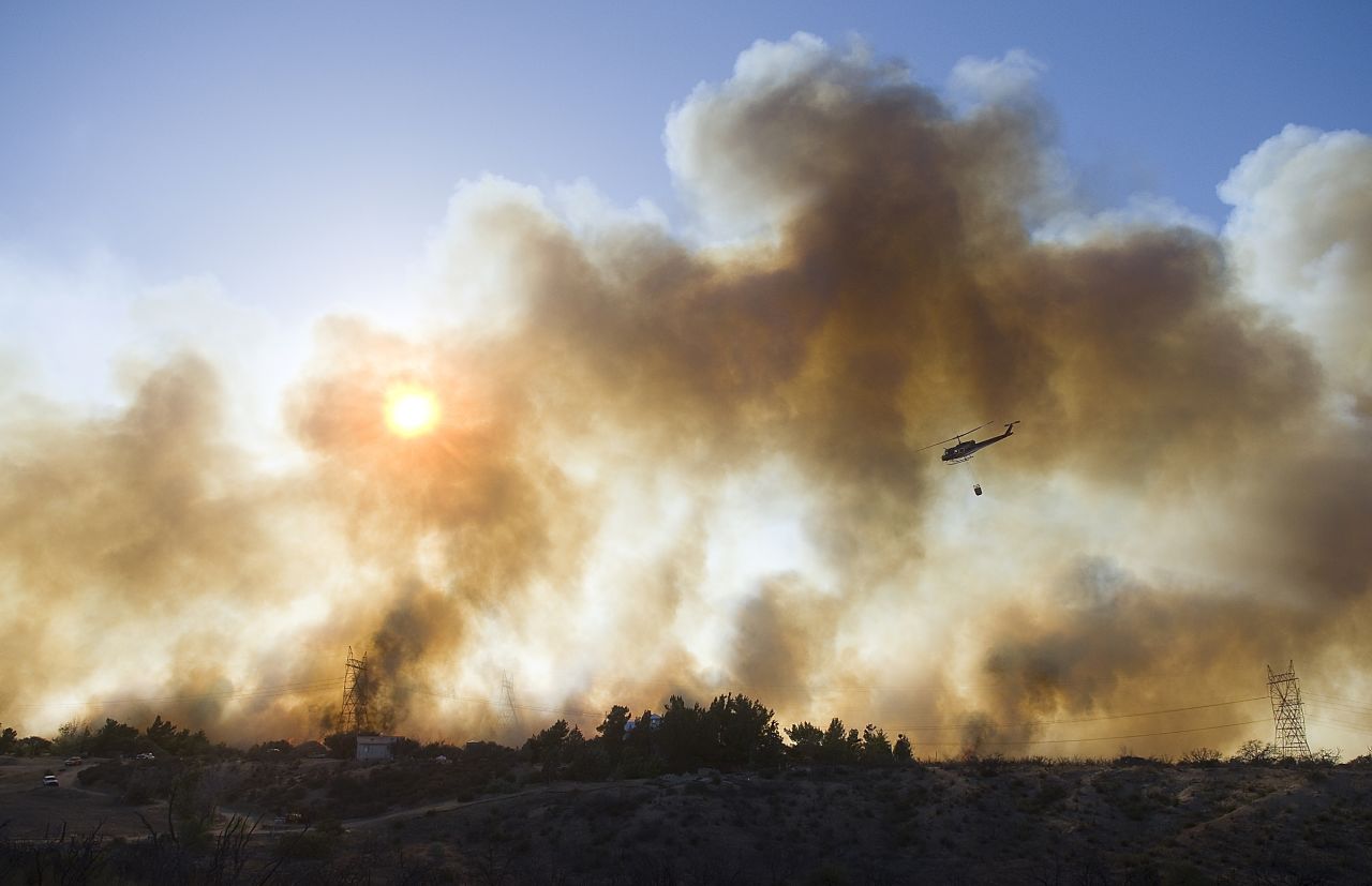 A helicopter prepares to drop water over a fire near Oak Hills, California, on July 17.