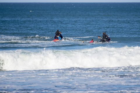 Fanning and Julian Wilson, in red, are rescued by personal watercraft.