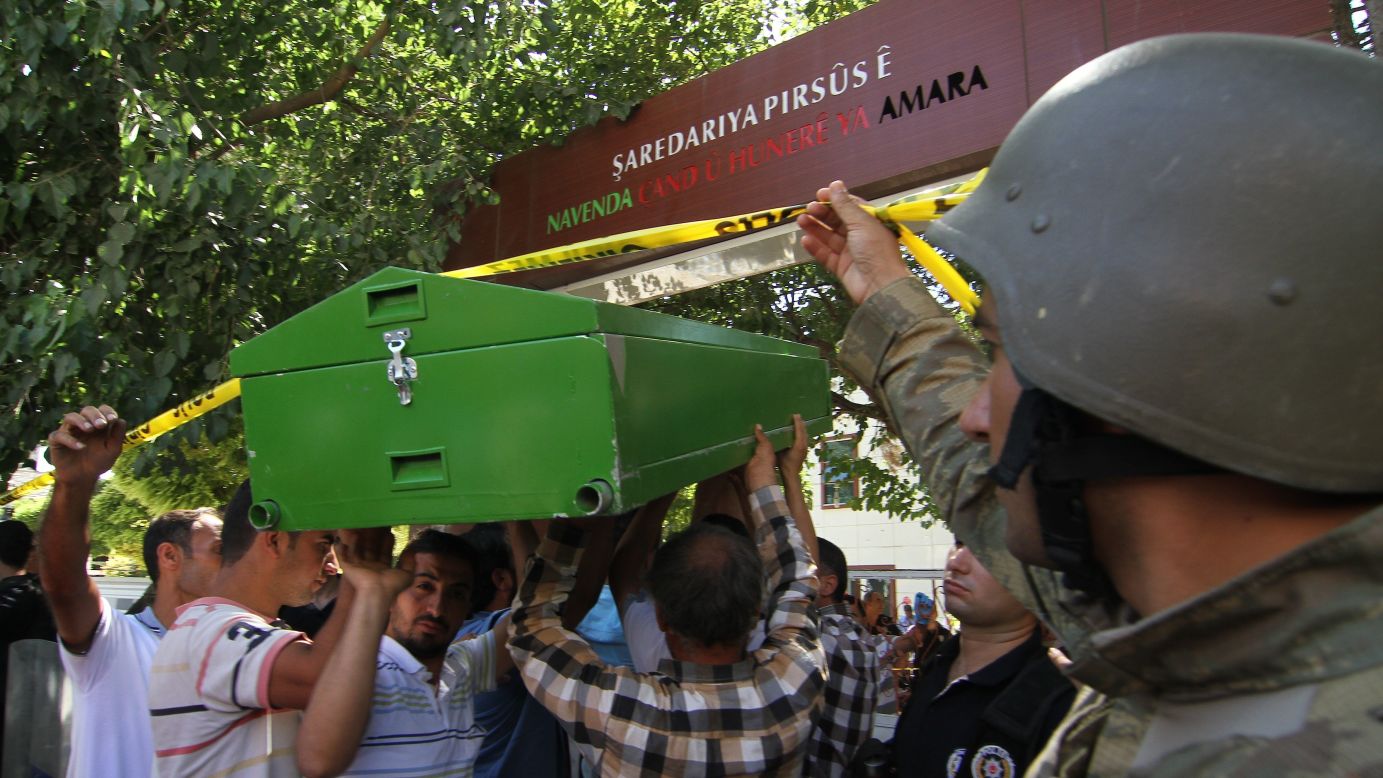 Men carry bodies away from the scene on July 20. 