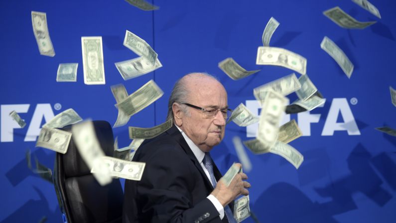 FIFA President Sepp Blatter <a href="index.php?page=&url=http%3A%2F%2Fwww.cnn.com%2F2015%2F07%2F20%2Ffootball%2Ffootball-fifa-congress-platini%2Findex.html" target="_blank">is showered by dollar bills</a> during a news conference in Zurich, Switzerland, on Monday, July 20. The money was thrown at Blatter by British comedian Simon Brodkin, who was then ushered away from the stage. Blatter has led soccer's governing body since 1998, but he has decided to stand down as FIFA battles corruption scandals.