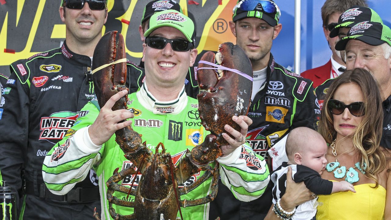 NASCAR driver Kyle Busch holds a lobster "trophy" after winning the Sprint Cup race in Loudon, New Hampshire, on Sunday, July 19. At right is Busch's wife, Samantha, holding their young son Brexton.