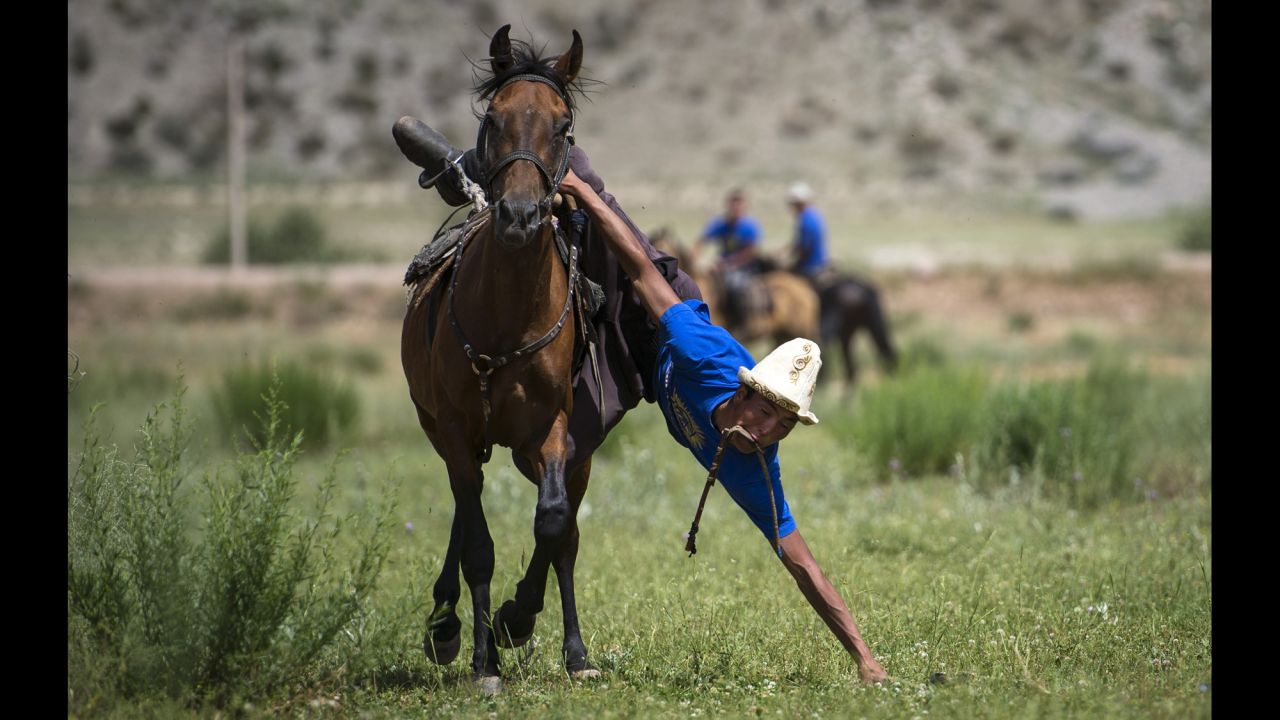 A man in Kyzyl-Oi, Kyrgyzstan, takes part in the game of "tyin enmei," which involves picking up coins from the ground while racing on horseback, on Saturday, July 18. Horses have always played a huge role in the daily life of the Kyrgyz people. The majority of the rural population follows a semi-nomadic way of life. Almost everyone can ride a horse, and horse games have been passed from generation to generation.