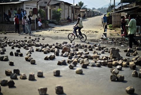 A man rides past a barricade set up by protesters in Bujumbura on July 21. Animosity against Nkurunziza <a href="http://www.cnn.com/2015/05/14/world/gallery/burundi-unrest/index.html" target="_blank">boiled over in April</a> when he expressed his intention to run for a third term. There have been protests and a failed coup.