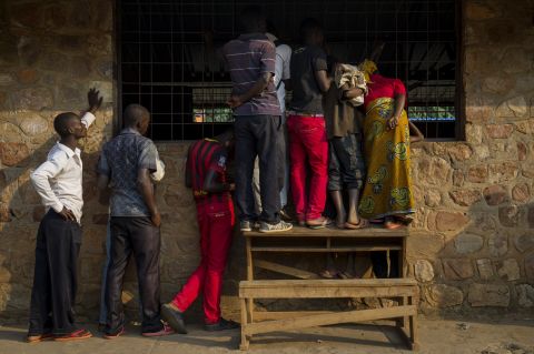 People watch through a window as voting officials count ballot papers in Mubimbi, Burundi, on July 21.